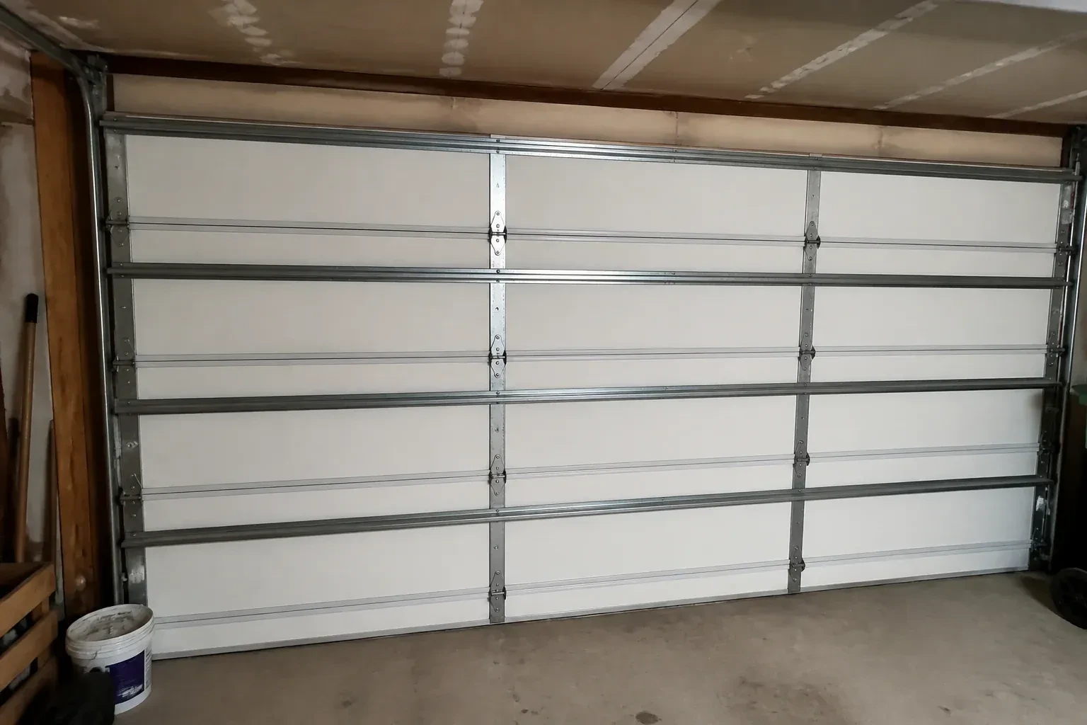 Interior of a closed sectional door with horizontal metal reinforcement struts. — Wind-Rated Garage Door Replacement, Haldimand County